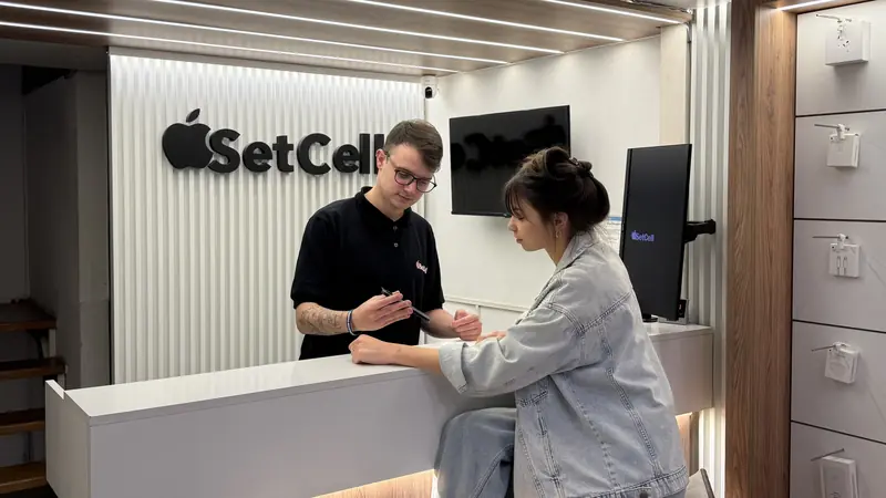 Asesor de SetCell mostrándole un iPhone a una clienta en el mostrador del local de Nueva Córdoba