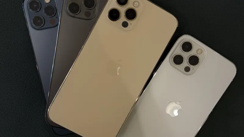 Cuatro iPhone 12 Pro en distintos colores sobre una mesa oscura