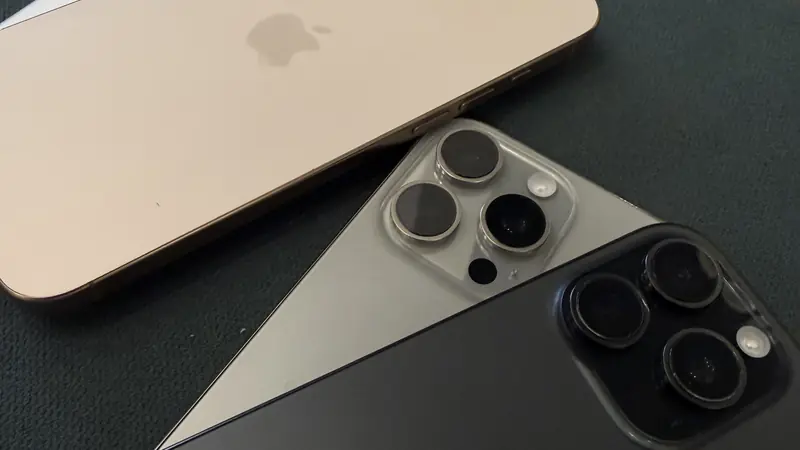 Tres iPhone 16 Pro Max en distintos colores sobre una mesa oscura