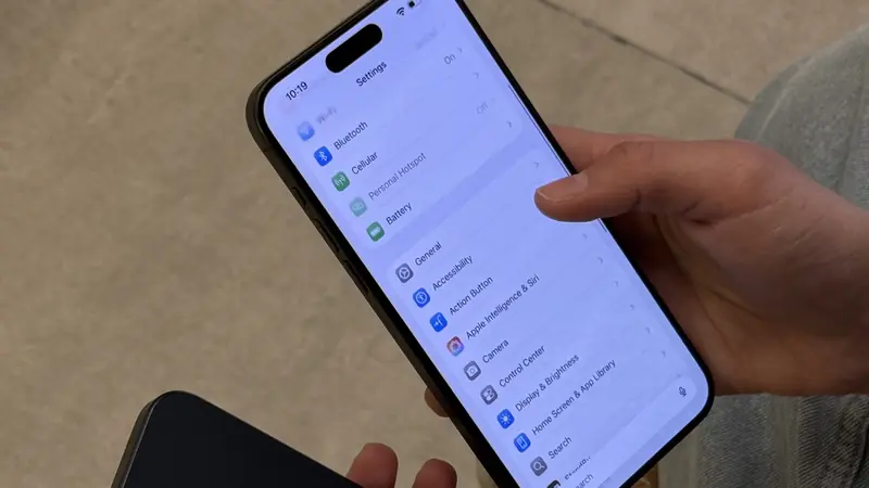 Persona revisando la pantalla de Ajustes de un iPhone 15 Pro Max, con la opción Batería visible